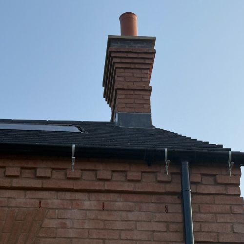 SureFix rise and fall gutter bracket installed on a brick building — zero masonry damage